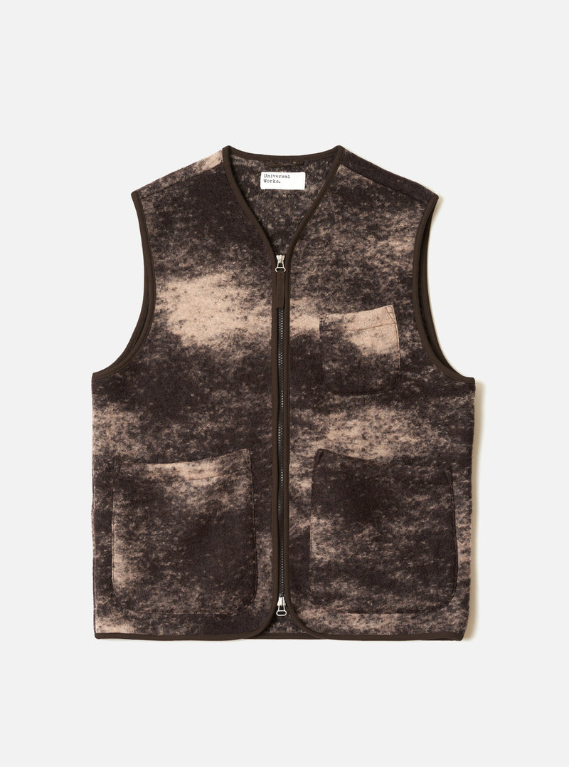 A full-length front view of a model wearing the Brown Cloud Camo Knit Zip Gilet against a neutral studio background, displaying the full-zip closure, sleeveless cut, and brown cloud camo knit wool finish.