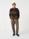 Full-length front view of a model wearing the Brown Pino Wool Fleece Cardigan in a studio setting with a clean background, showing how the cardigan fits over a shirt with its buttoned front and pockets.