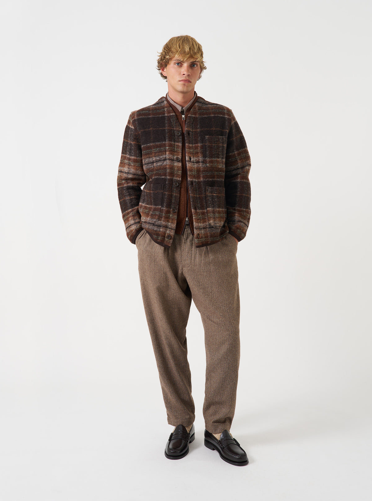 Full-length front view of a model wearing the Brown Pino Wool Fleece Cardigan in a studio setting with a clean background, showing how the cardigan fits over a shirt with its buttoned front and pockets.