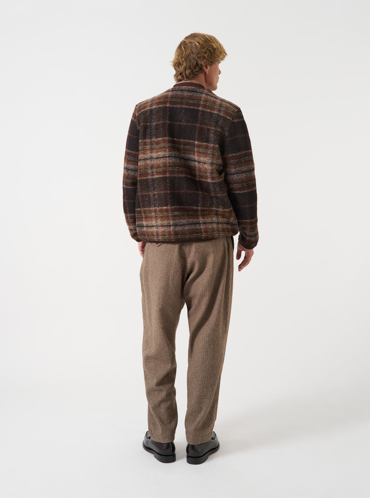 Back view of a model wearing the Brown Pino Wool Fleece Cardigan in a neutral studio setup, highlighting the relaxed drop-shoulder cut, smooth back panel, and ribbed hem structure of the brown fleece.