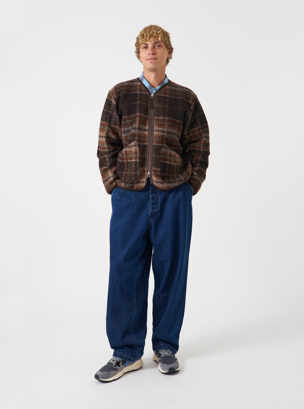 Front view of a model wearing the Brown Pino Wool Fleece Military Liner Jacket in a clean studio setting, showcasing the tailored fit, zipped front closure, and layering style over casual trousers.
