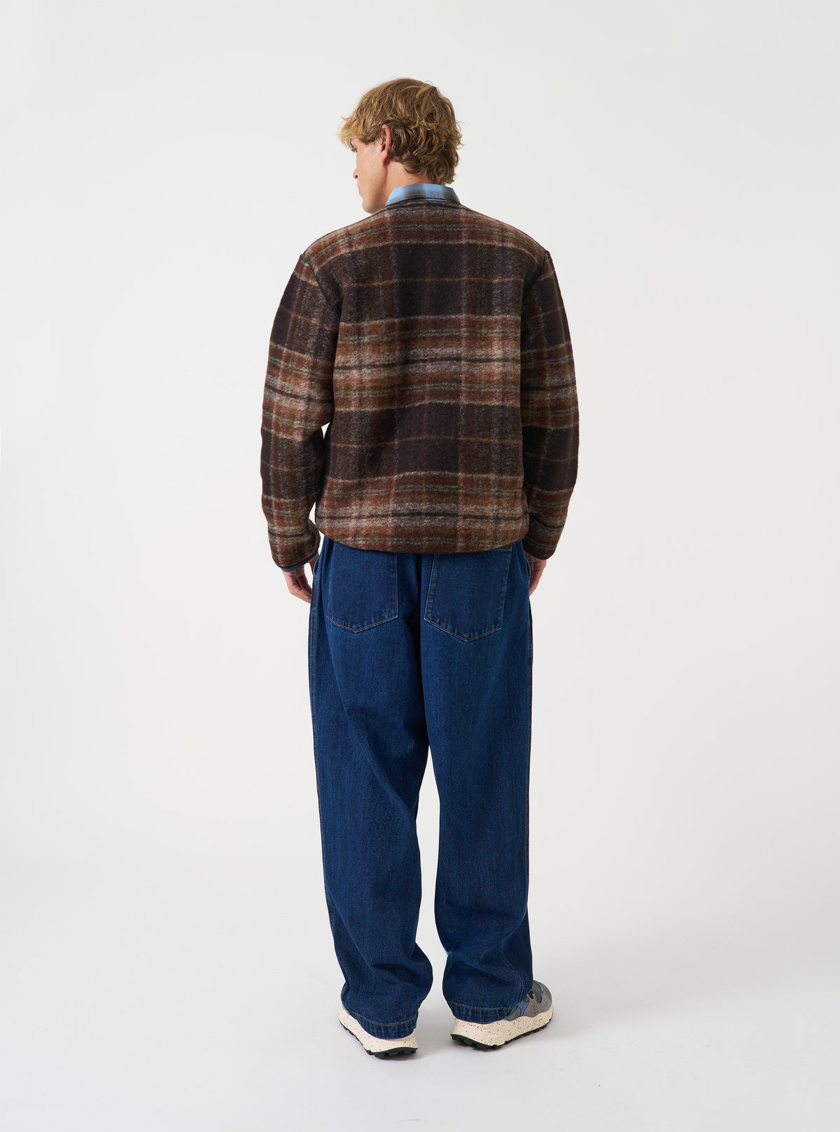 Back view of a model wearing the Brown Pino Wool Fleece Military Liner Jacket against a plain studio backdrop, displaying the comfortable fit across the shoulders and clean back profile of the jacket.