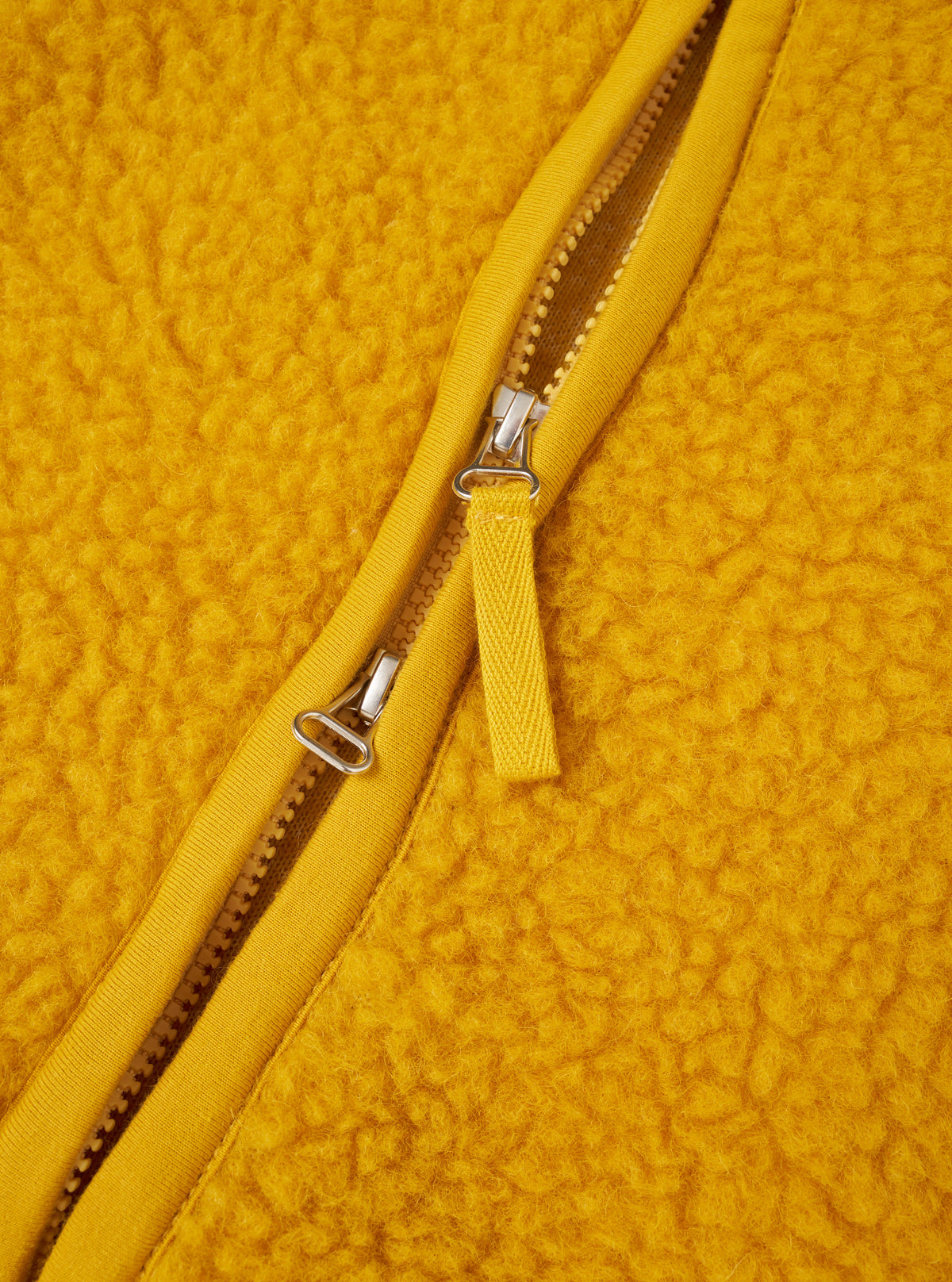 A close-up view of a model wearing the Yellow Artic Fleece Hep Mountain Jacket, focusing on the collar, zipper, and pocket details. The shot highlights the soft fleece texture and bright yellow fabric in a studio setting.