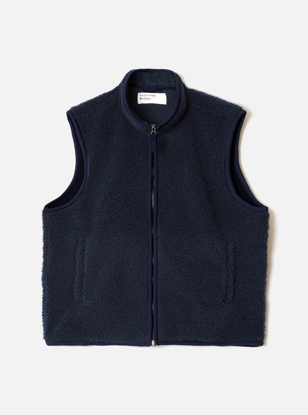 A full-length front view of a model wearing the Navy Artic Fleece Hep Mountain Gilet in a bright studio setting. The image showcases the sleeveless design, front zip closure, side pockets, and deep navy wool-blend fleece.