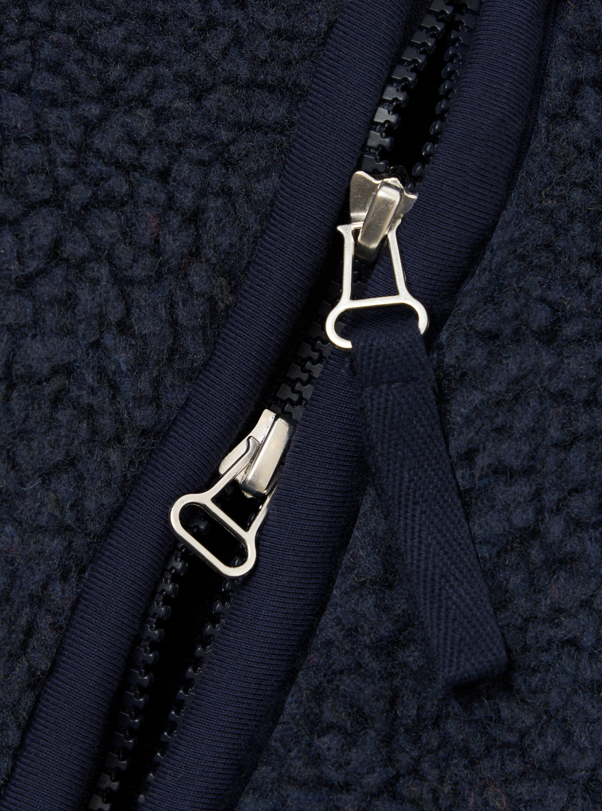A close-up detail shot of a model wearing the Navy Artic Fleece Hep Mountain Gilet, highlighting the chest area, zip pull, collar trim, and tactile navy fleece fabric against a neutral studio backdrop.