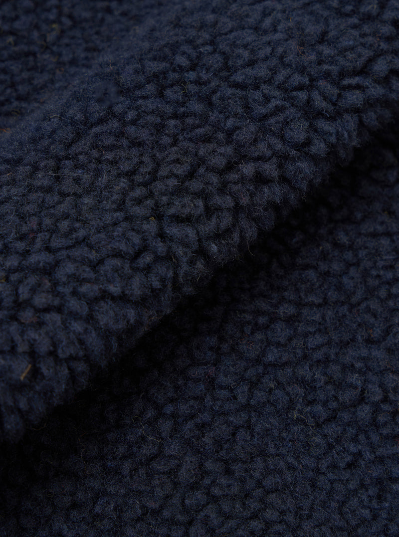 A close-up swatch image showcasing the dark navy fabric texture of the Navy Artic Fleece Hep Mountain Gilet on a solid white background, emphasizing the soft fleece pile and rich recycled wool fiber mix.