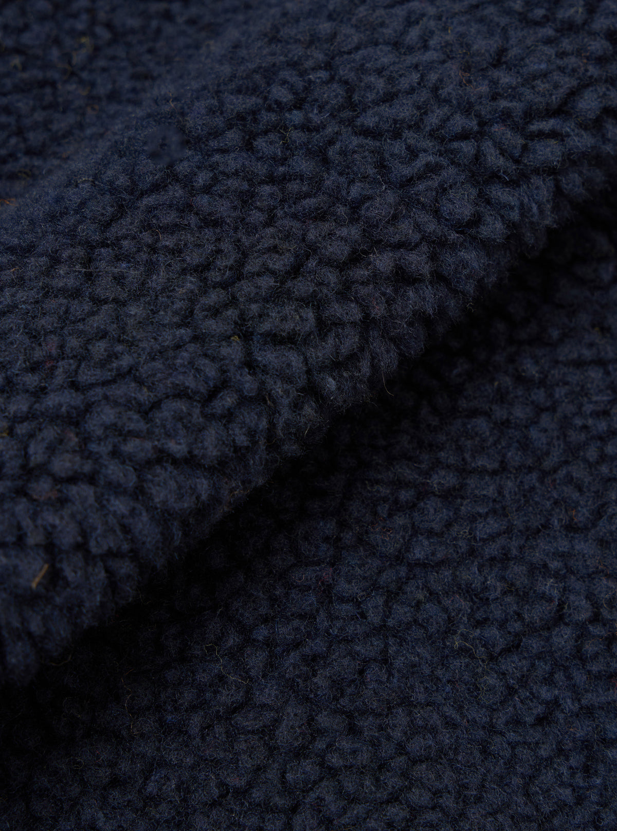 A close-up swatch image showcasing the dark navy fabric texture of the Navy Artic Fleece Hep Mountain Gilet on a solid white background, emphasizing the soft fleece pile and rich recycled wool fiber mix.