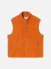 A full-length front view of a model wearing the Orange Artic Fleece Hep Mountain Gilet in a studio set with a neutral background. The photo highlights the vibrant orange fleece, zip front, and sleeveless gilet cut.