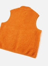 A back view of a model wearing the Orange Artic Fleece Hep Mountain Gilet standing against a neutral studio backdrop, showing the overall fit, hem cut, and bright orange fleece material across the back panel.