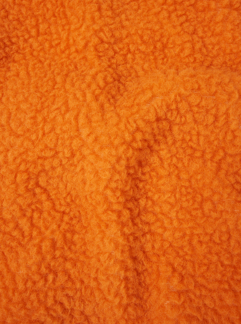 A fabric swatch close-up image of the Orange Artic Fleece Hep Mountain Gilet displayed on a white background, highlighting the intense orange color, fuzzy fleece pile, and wool-blend material texture.