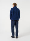 Back view of a model wearing the Blue Bouclet Fleece Lancaster Jacket in a studio setting. The photograph showcases the clean fit across the shoulders, straight hemline, and textured bouclé fleece material in deep blue.