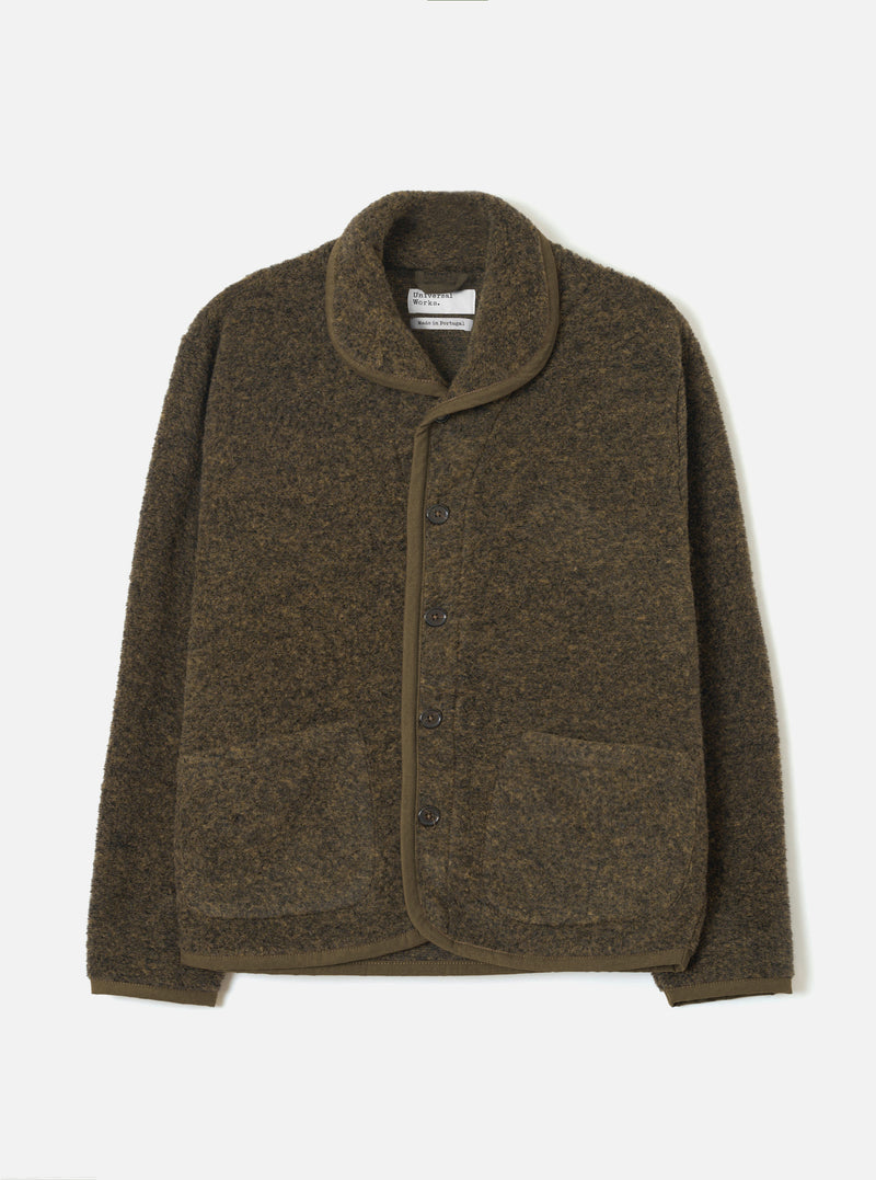 Brown boucle style fleece Lancaster jacket laid flat on a light grey studio backdrop. Shawl collar with tonal brown knit trim edging the front placket, cuffs, and hem. Four dark buttons fasten the centre front. Two large patch pockets sit at the lower front. Universal Works woven label visible at the neck.