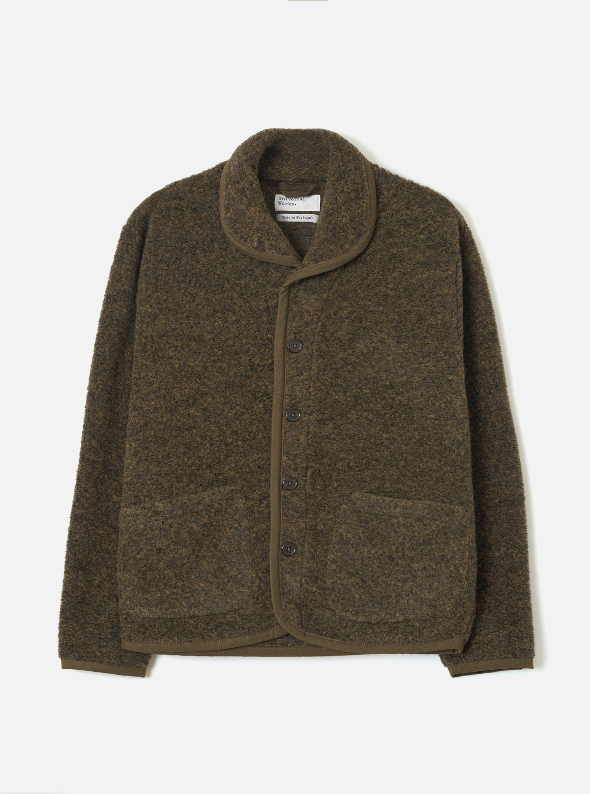 Brown boucle style fleece Lancaster jacket laid flat on a light grey studio backdrop. Shawl collar with tonal brown knit trim edging the front placket, cuffs, and hem. Four dark buttons fasten the centre front. Two large patch pockets sit at the lower front. Universal Works woven label visible at the neck.