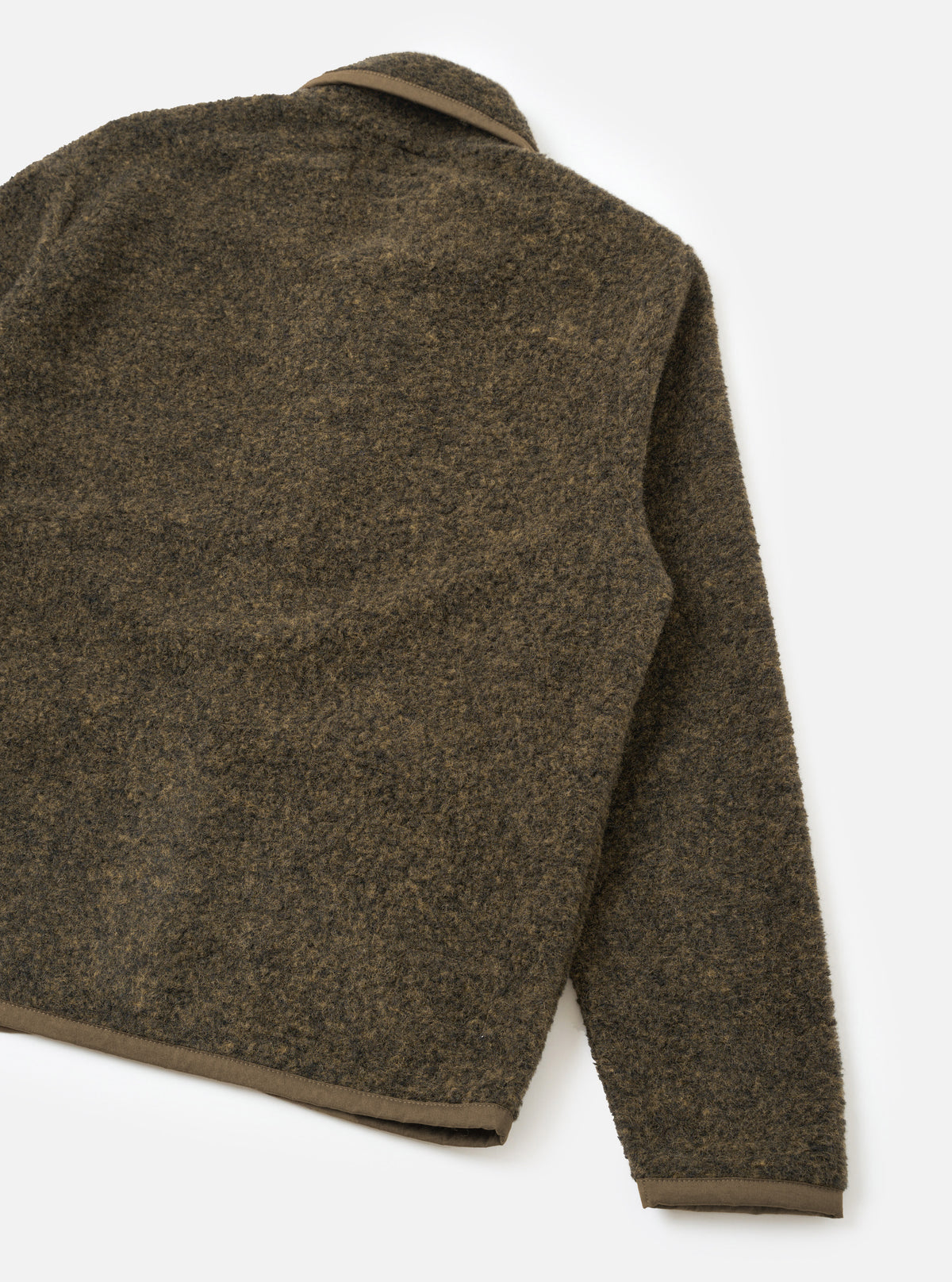 Back view of a brown boucle style fleece Lancaster jacket, laid flat on a white studio surface. The textured, looped fleece fabric shows a mottled brown and dark grey tone. A tan grosgrain trim edges the collar, cuffs, and straight hem. One sleeve extends to the right.