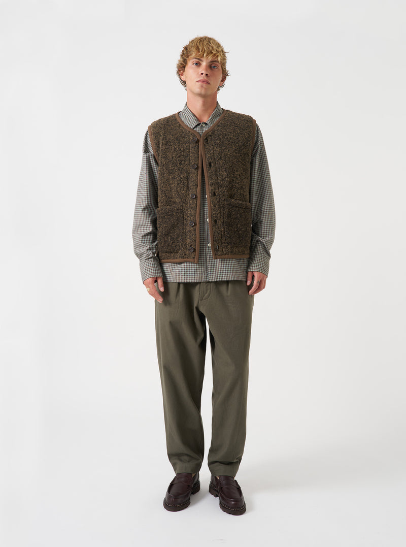 Studio shot featuring a model wearing the Brown Bouclet Fleece Lancaster Gilet. The front view showcases the rich brown bouclé fleece material, sleeveless cut, front button fastening, and convenient patch waist pockets.