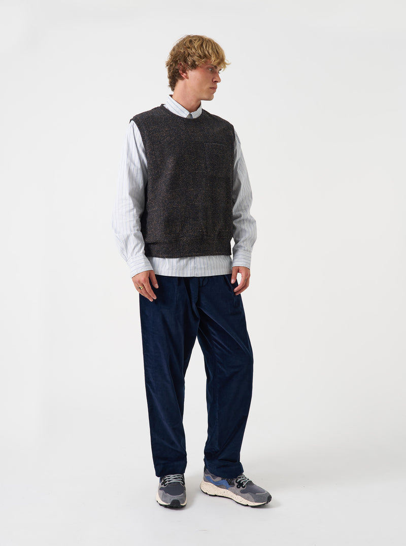 Front view of a model wearing the Navy Deca Light Knit Sleeveless Crew vest in a studio setting. The image highlights the sleeveless design, ribbed crew neck collar, armholes, and lightweight navy knit texture.
