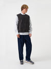 Front view of a model wearing the Navy Deca Light Knit Sleeveless Crew vest in a studio setting. The image highlights the sleeveless design, ribbed crew neck collar, armholes, and lightweight navy knit texture.