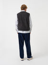 Back studio shot of a model wearing the Navy Deca Light Knit Sleeveless Crew vest against a neutral background. The photograph displays the clean rear fit, smooth knit texture, and simple sleeveless silhouette.