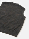 Navy sleeveless crew knit in a dark navy, brown and grey Glen plaid pattern. Flat lay on a white surface, shot at an angle showing the back panel, armhole, and ribbed hem. The wool-blend fabric has a textured, lightly mottled finish with a large-scale check woven throughout.