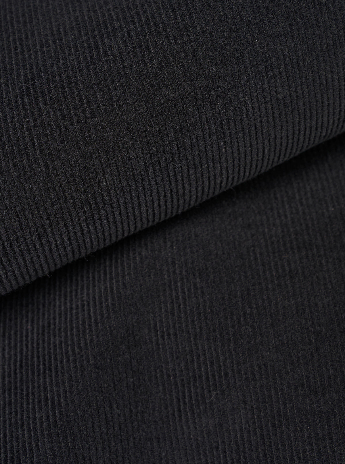 Close-up fabric swatch image of the Black Fine Cord Bakers Overshirt on a white background, detailing the distinct narrow ridges, soft texture, and deep black shade of the fine corduroy cotton material.