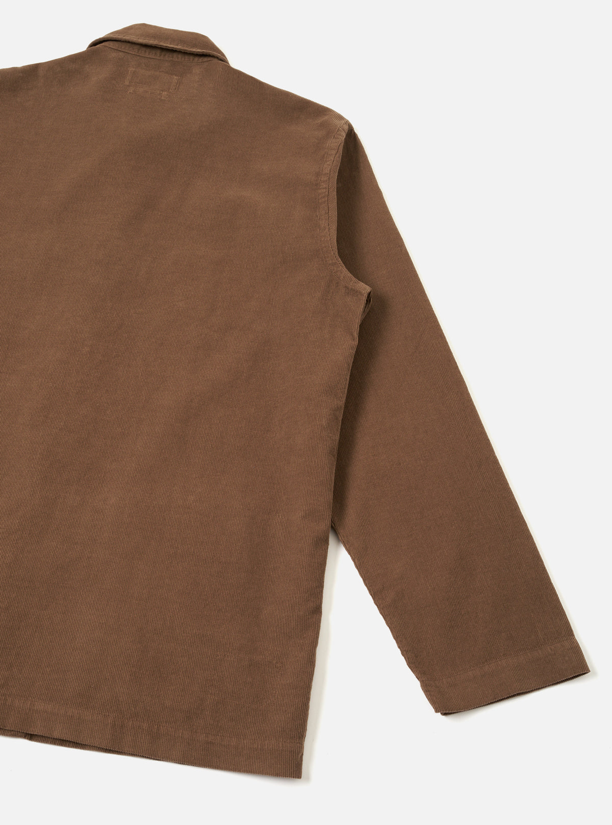 Back product photograph of the Brown Fine Cord Bakers Overshirt on a seamless white backdrop, showcasing the clean rear yoke, straight hem finish, and fine-ribbed texture of the warm brown corduroy material.