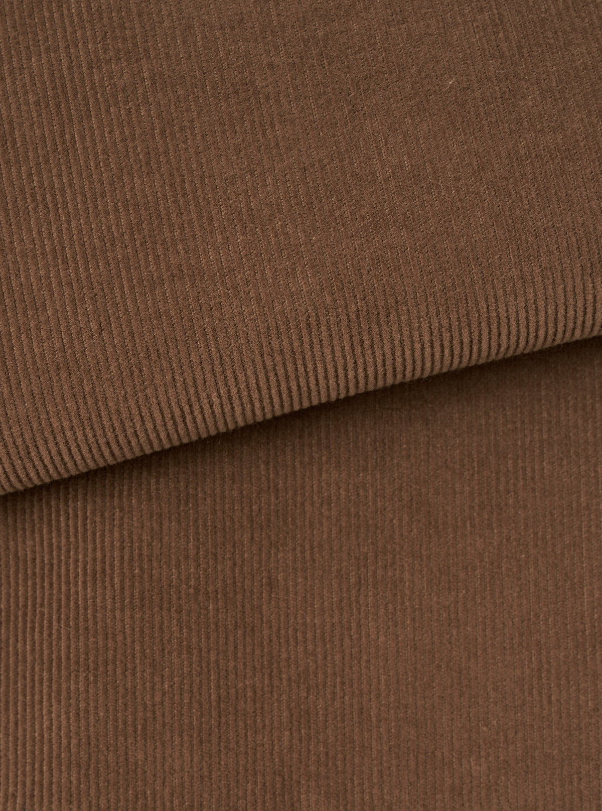 An extreme close-up fabric swatch of the Universal Works Brown Fine Cord Bakers Overshirt, showing the fine-wale cotton corduroy texture and rich brown tone in detail against a clean, plain white background.
