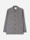A male model wearing the Universal Works Grey Fine Cord Bakers Overshirt, styled casually with the front fully buttoned, shown from the front against a plain off-white background to highlight the relaxed fit.