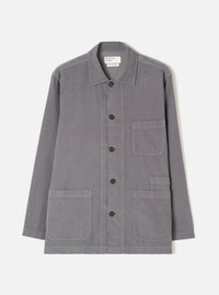 A male model wearing the Universal Works Grey Fine Cord Bakers Overshirt, styled casually with the front fully buttoned, shown from the front against a plain off-white background to highlight the relaxed fit.
