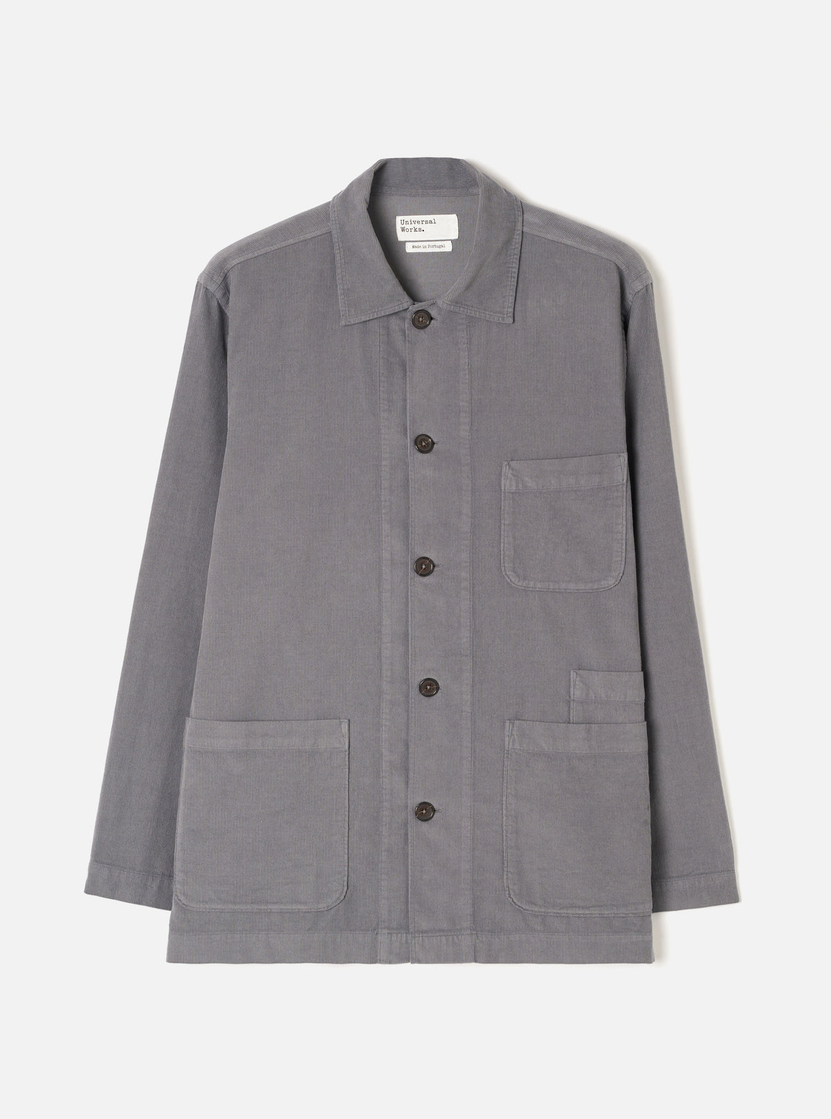 A male model wearing the Universal Works Grey Fine Cord Bakers Overshirt, styled casually with the front fully buttoned, shown from the front against a plain off-white background to highlight the relaxed fit.