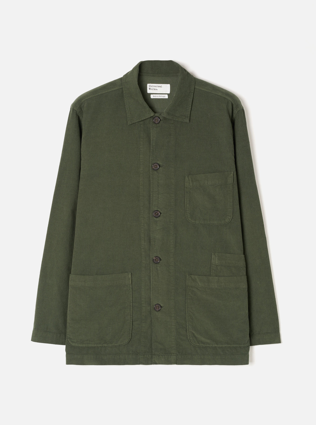 A male model wearing the Universal Works Olive Fine Cord Bakers Overshirt, shown from the front against a plain white background, highlighting its relaxed fit, front patch pockets, and fine corduroy texture.