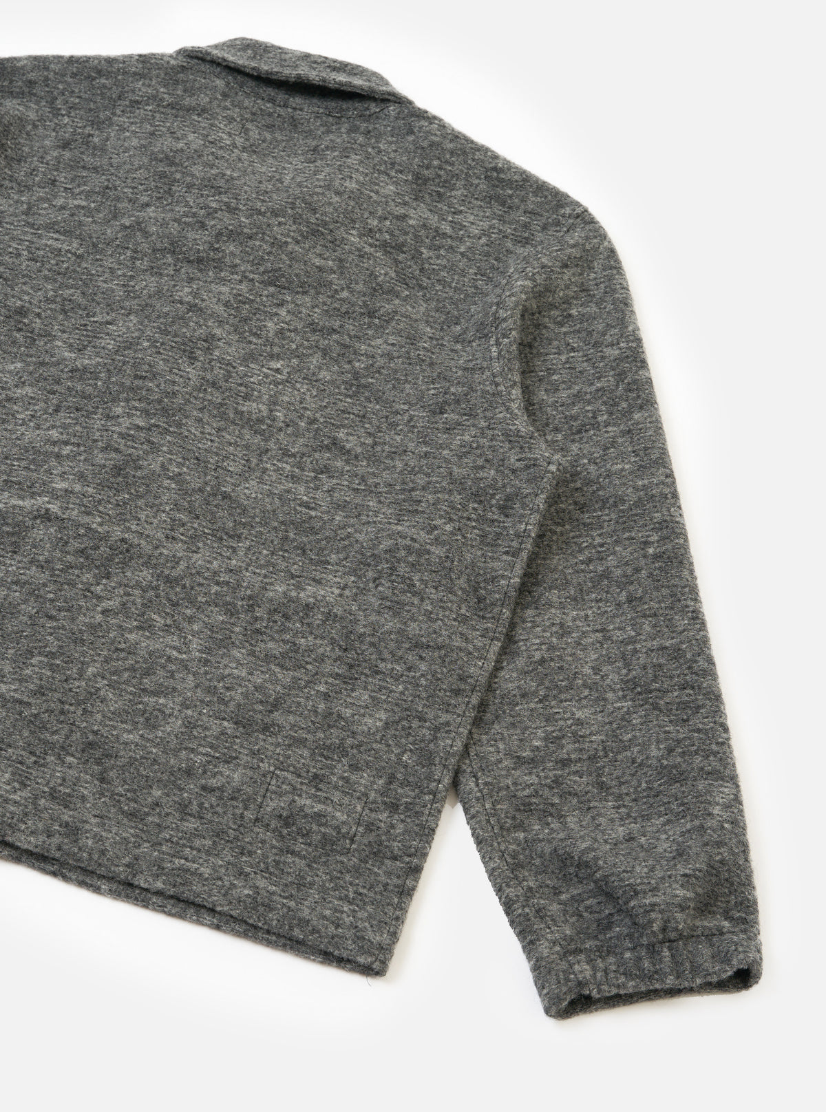 Back view of a male model wearing the Universal Works Grey Marl Wool Mix Knit Rams Jacket against a plain background, displaying the relaxed fit, clean hem, and textured grey wool mix fabric.
