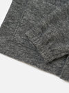 A close-up shot of the Universal Works Grey Marl Wool Mix Knit Rams Jacket on a plain background, displaying the zipper detail, soft fleece collar, and textured wool blend knit pattern.