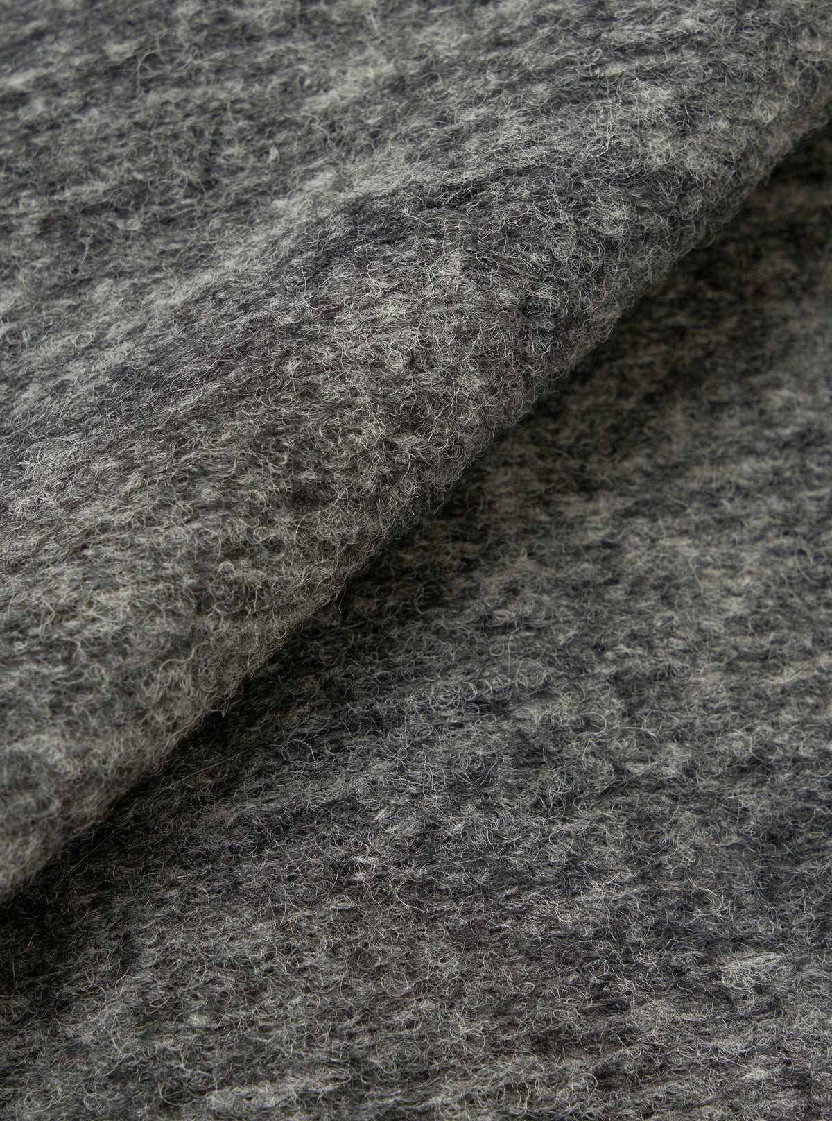 An extreme close-up fabric swatch of the Universal Works Grey Marl Wool Mix Knit Rams Jacket, showcasing the rich texture and flecked grey wool blend knit material against a plain background.