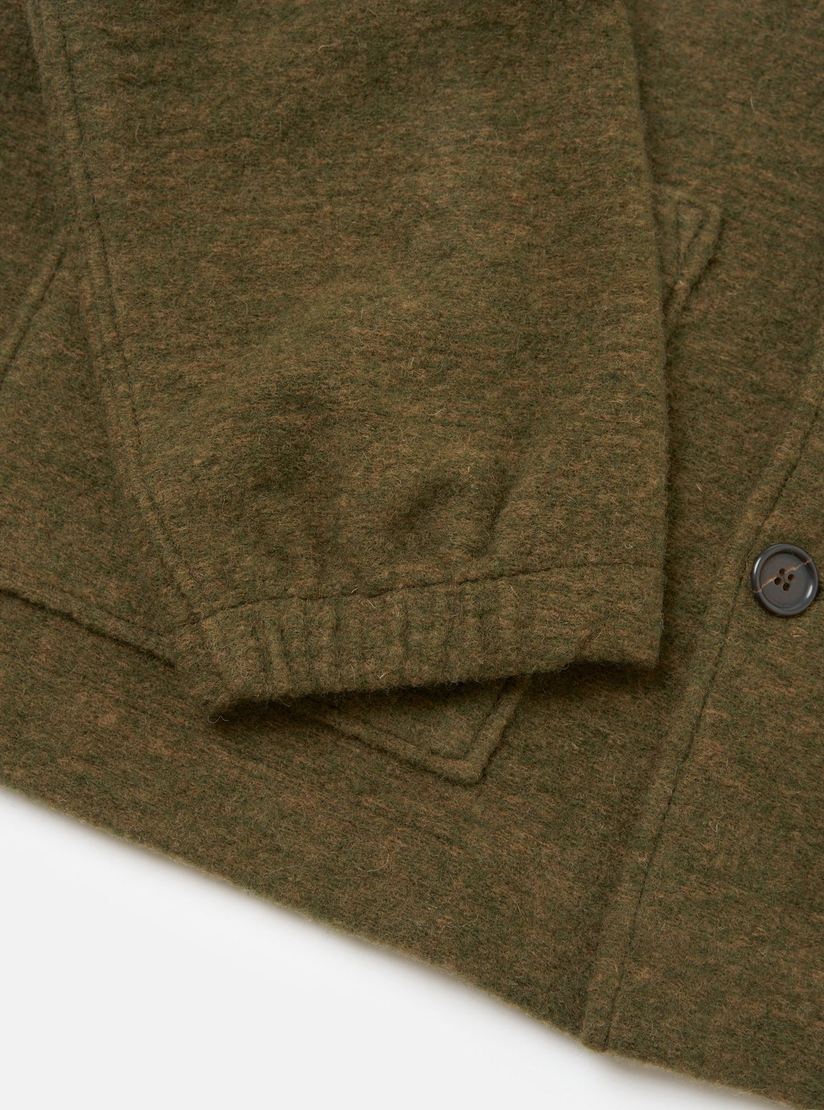 A close-up studio shot of a model wearing the Olive Wool Mix Knit Rams Jacket, focusing on the collar, button closure, and rich textured surface of the olive green wool mix fleece material.