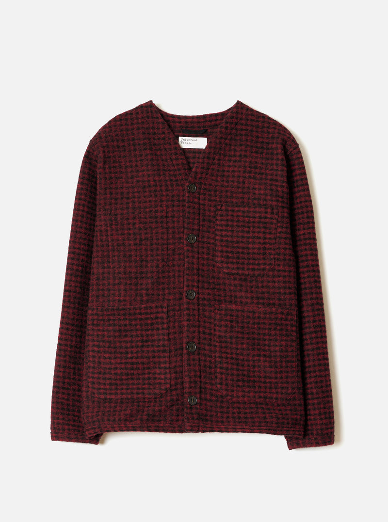 A full-length front view of a model wearing the Black/Red 533 Wool Mix Cardigan in a plain studio setting, showing the bold black and red patterned knit, front buttons, and comfortable V-neck style.