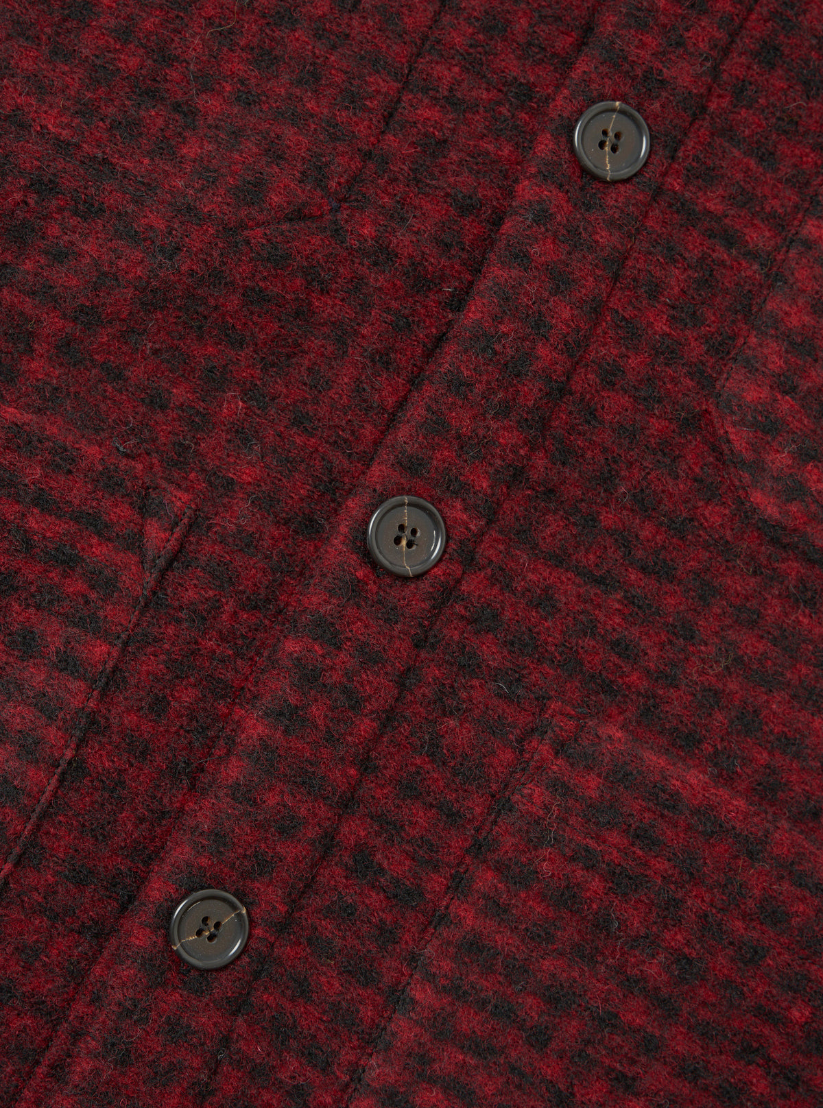 A close-up view of a model wearing the Black/Red 533 Wool Mix Cardigan, detailing the V-neckline, front buttons, and high-contrast black and red wool blend pattern against a studio background.