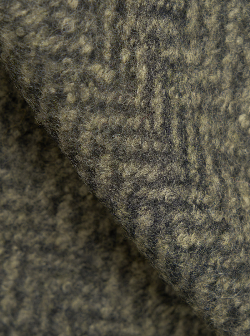 A macro fabric swatch photo of the Olive Raven Fleece Advance Cardigan set on a white background, capturing the deep pile texture, soft wool fiber weave, and earth-toned olive green shade of the fleece.