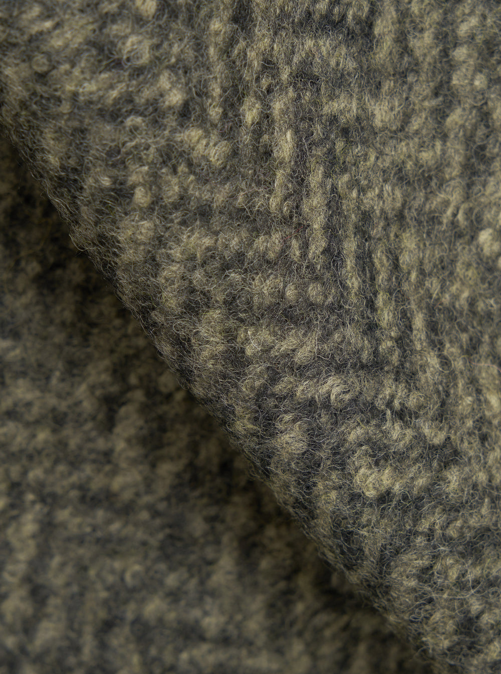 A macro fabric swatch photo of the Olive Raven Fleece Advance Cardigan set on a white background, capturing the deep pile texture, soft wool fiber weave, and earth-toned olive green shade of the fleece.