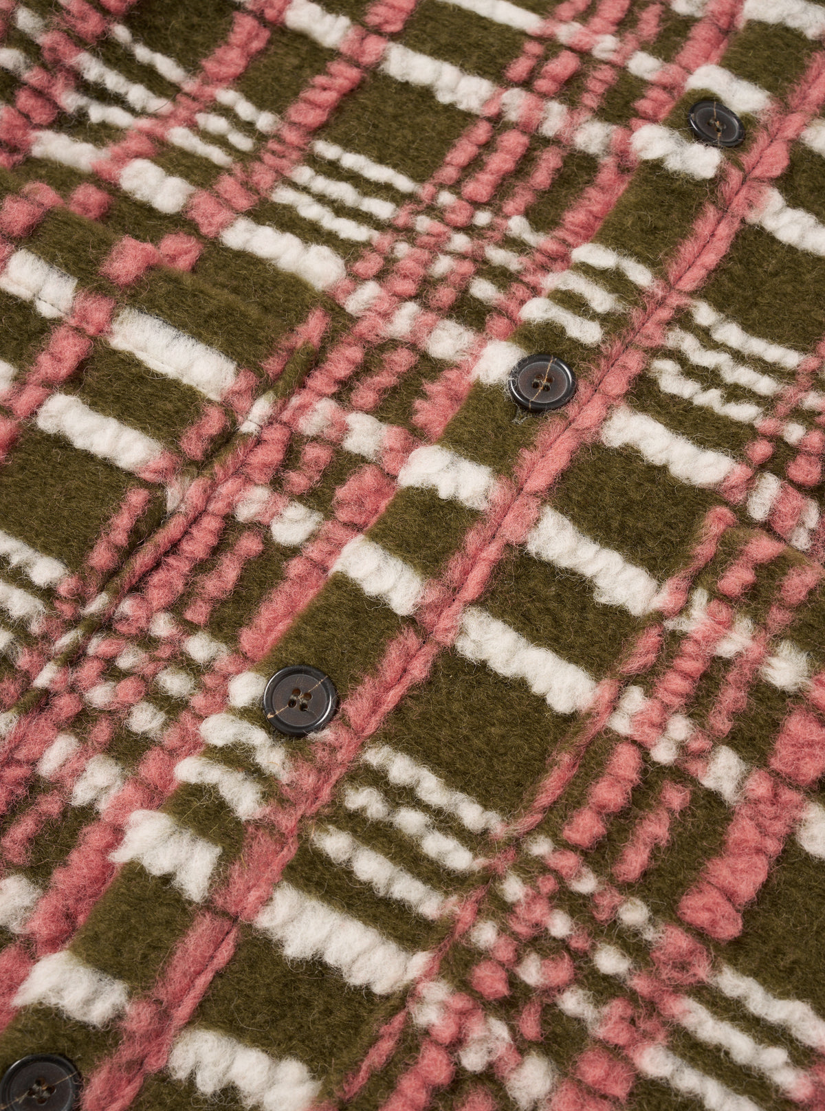 A close-up detail shot of a model wearing the Olive Duomo Fleece Cardigan, focusing on the V-neck button closure, front patch pocket, and tactile olive green fleece texture against a light studio backdrop.