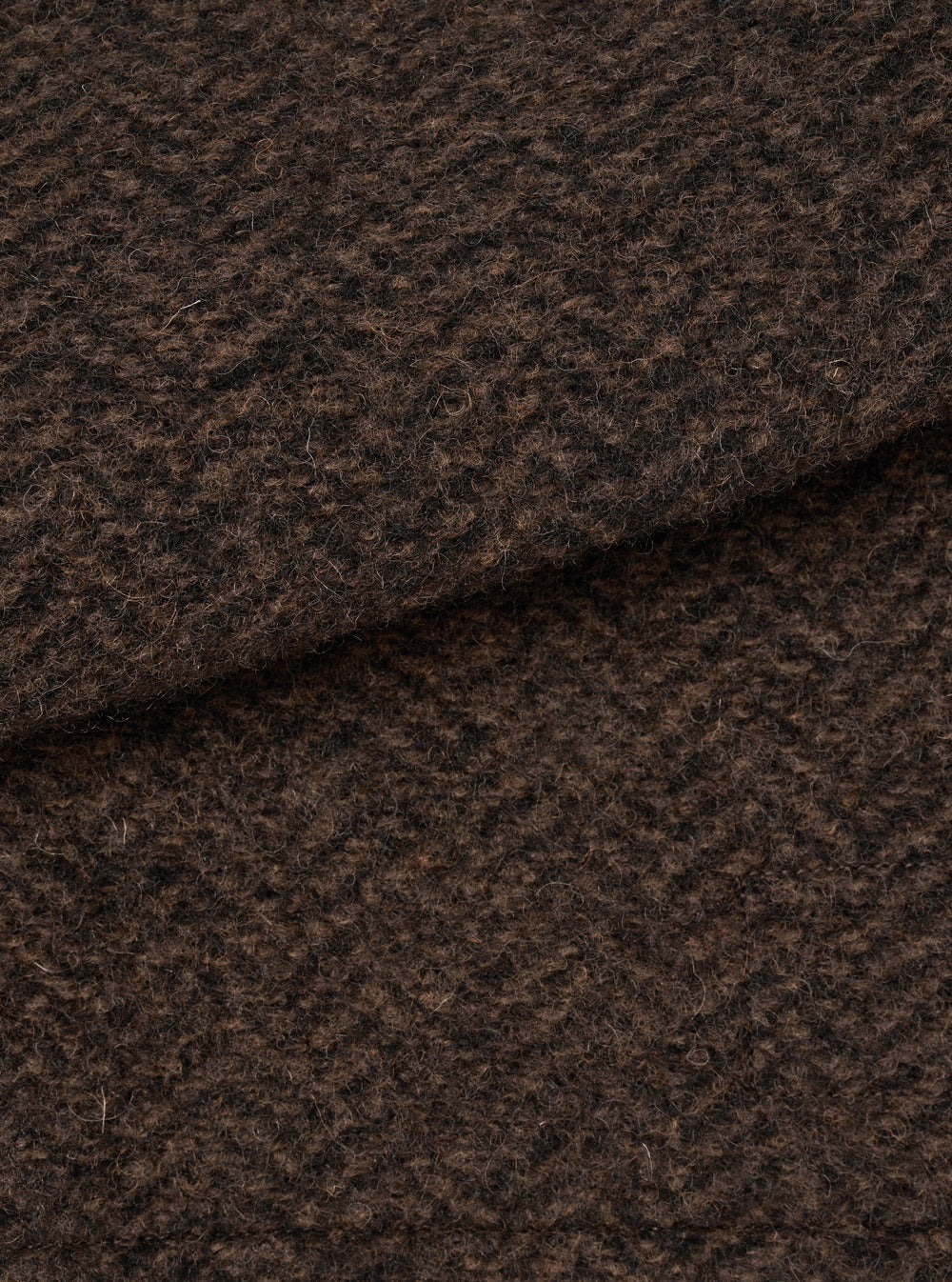 A close-up swatch image showing the textured brown marl wool fleece fabric of the Brown Raven Fleece Rams Jacket on a plain white background, highlighting the dense knit and warm marled color.