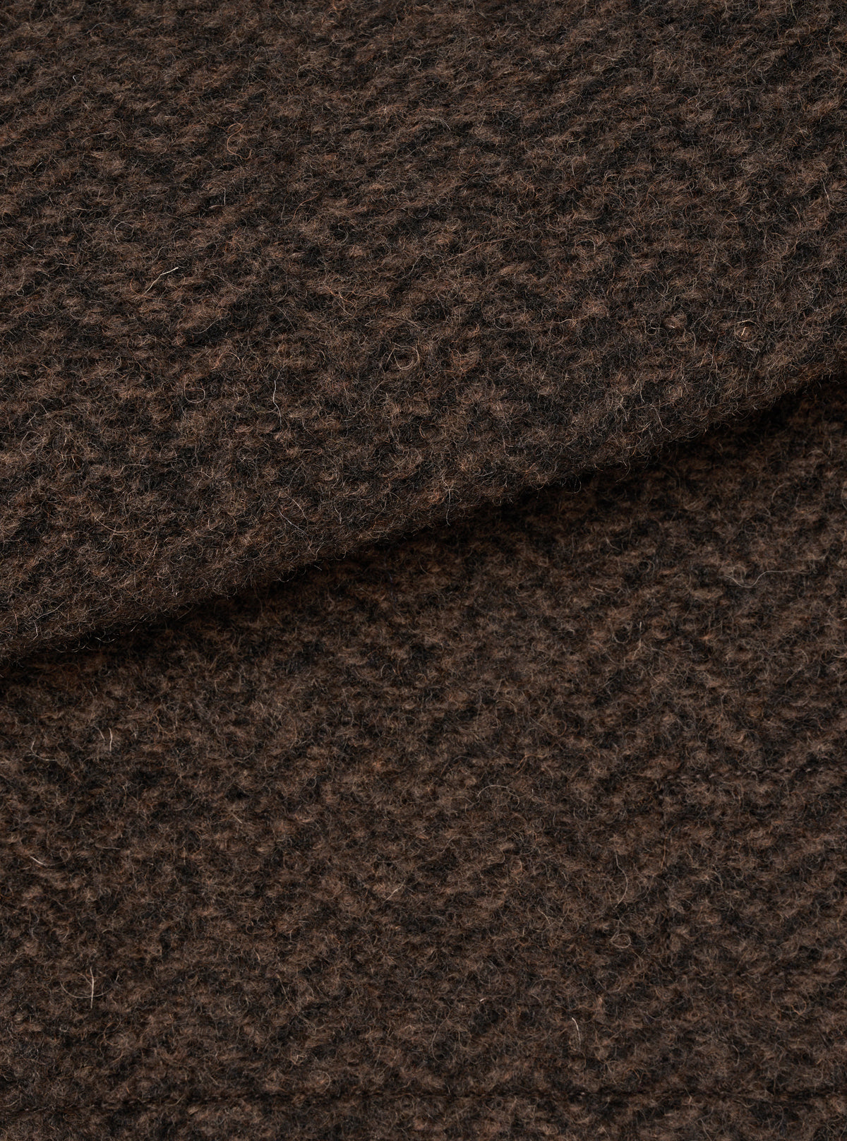 A close-up swatch image showing the textured brown marl wool fleece fabric of the Brown Raven Fleece Rams Jacket on a plain white background, highlighting the dense knit and warm marled color.