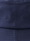 A top-down view of the Navy Canvas Lewis Hat laid flat on a neutral studio background, accentuating the circular crown construction, neat top stitching, and rich dark navy cotton material.