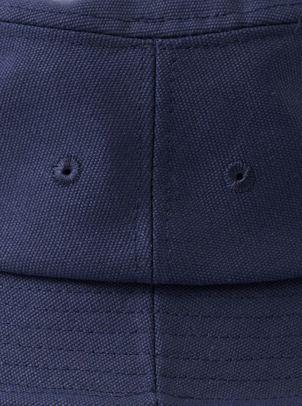 A top-down view of the Navy Canvas Lewis Hat laid flat on a neutral studio background, accentuating the circular crown construction, neat top stitching, and rich dark navy cotton material.