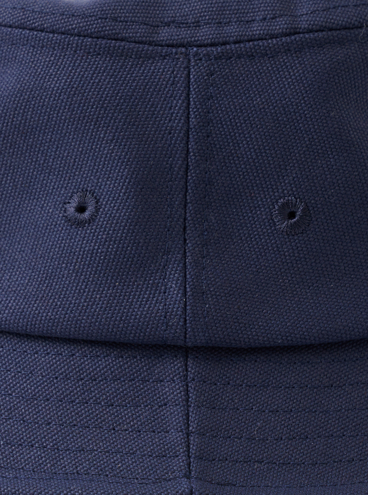A top-down view of the Navy Canvas Lewis Hat laid flat on a neutral studio background, accentuating the circular crown construction, neat top stitching, and rich dark navy cotton material.