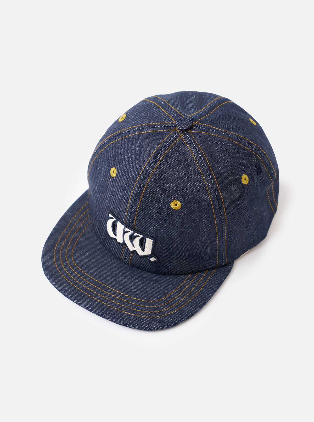 A side profile view of the Indigo 13oz Selvedge Denim Baseball Hat shown on a white background. The photo highlights the sturdy indigo denim texture, ventilation eyelets, and classic cap silhouette.