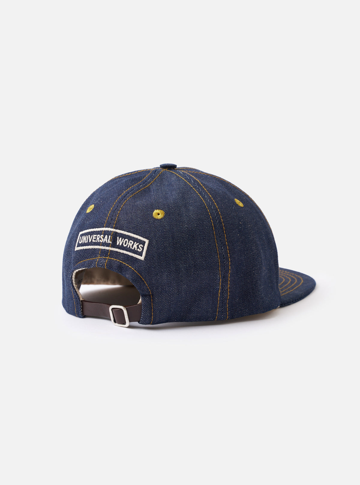A detailed close-up image of the back of the Indigo 13oz Selvedge Denim Baseball Hat against a clean white studio background, highlighting the adjustable back strap, brass buckle, and dark blue denim stitching.