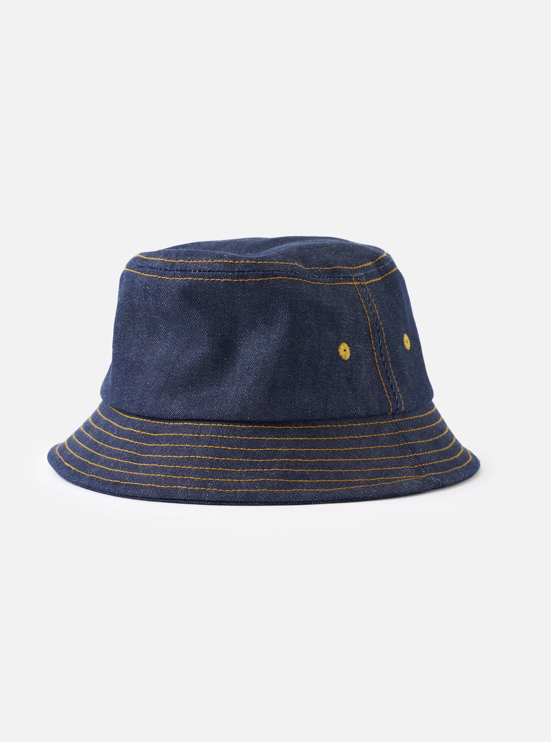 A full front view of the Indigo 13oz Selvedge Denim Lewis Hat displayed on a plain white background. The studio shot highlights the classic bucket hat shape, short brim, side eyelets, and dark indigo blue cotton denim fabric.