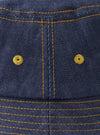 A top-down view of the Indigo 13oz Selvedge Denim Lewis Hat against a plain white background, showcasing the circular crown paneling, top stitching details, and dark blue organic cotton selvedge denim texture.