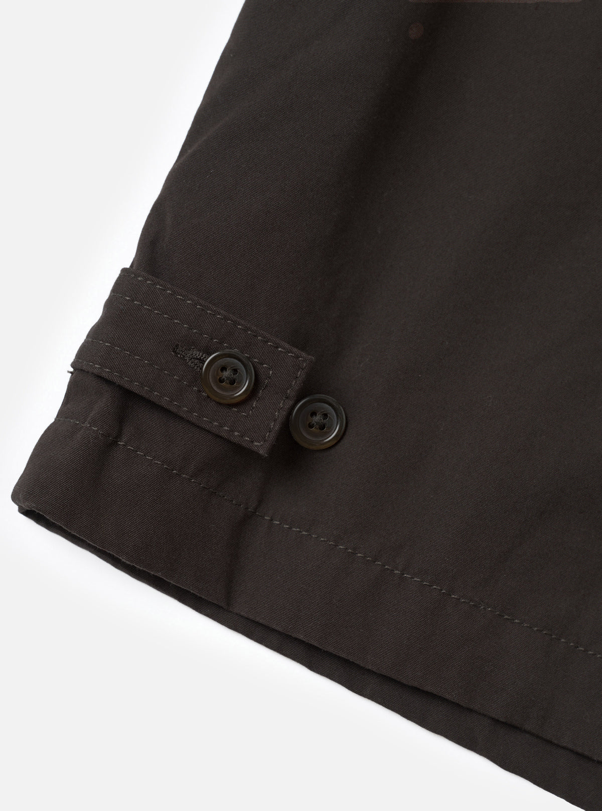 A close-up view of the Brown Micro Canvas Warmus Jacket on a white studio background, focusing on the front button closure, detailed stitching on the chest welt pocket, and smooth brown cotton canvas fabric.