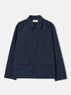 A front studio view of the Navy Micro Canvas Warmus Jacket set against a plain white background, featuring a classic pointed collar, button closure, chest pocket, and flap lower pockets in dark navy blue cotton canvas.